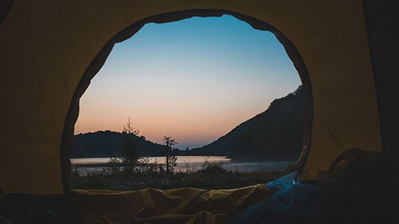 キャンプのテントの中から外を見ると、夜が明けていくような雰囲気になっている